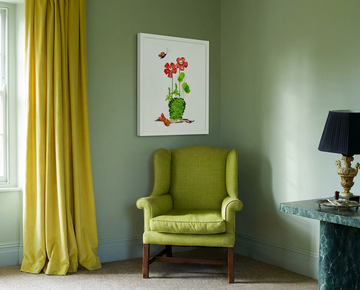 Plant Harmony botanical wall art in a white frame, hung in a calm green sitting room above a wingback chair.