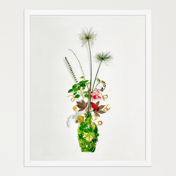 Tall arrangement of slender branches, green leaves, curled peels, and subtle blossoms on white. Botanical wall art by FloraFusion.