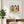 Garden Sisters botanical wall art print in a white frame, shown in a calm neutral room