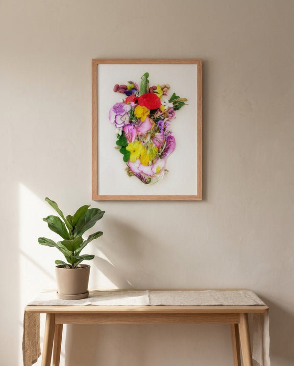 Heart in Bloom botanical wall art print in a red oak frame, shown in a calm neutral room
