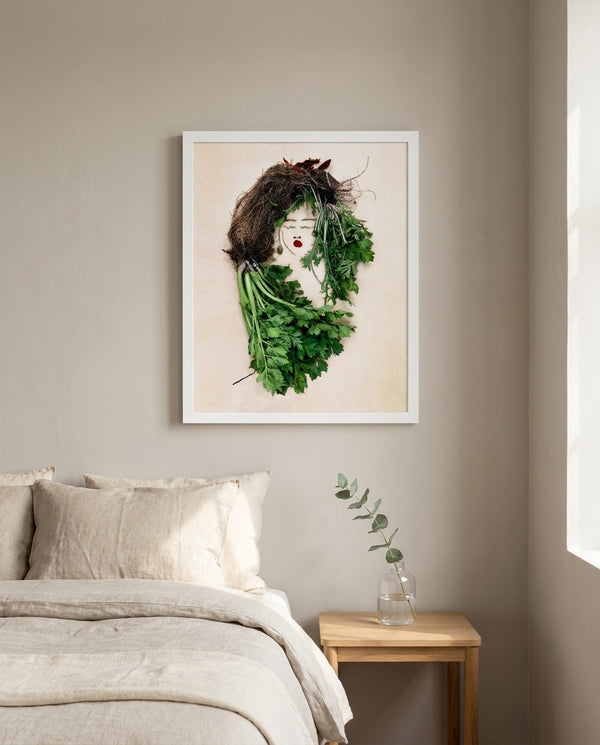The Celery Woman print in a white frame hanging in a bedroom