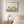 Cypress Afternoon nature-inspired park scene wall art print in a red oak wood frame hanging in a bedroom