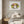 Garden Halo Lady in a white frame styled above a bed in a serene bedroom