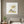 Garden Tender in a white frame above a linen sofa in a calm living room