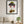 A Gentle Flourish in a black frame hung in a living room