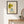 Girl in Bloom whimsical floral girl wall art print in a black frame hanging in an entryway