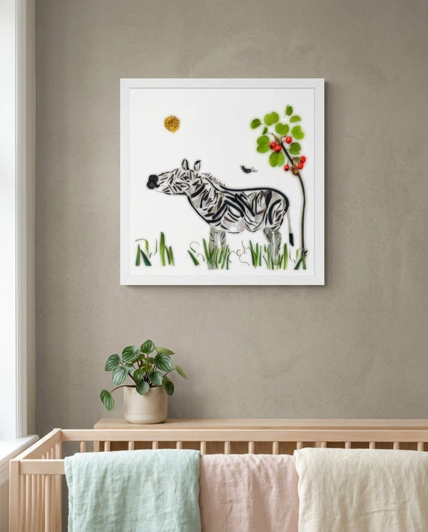 Meadow Zebra print in a white frame hanging in a nursery