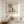 Mimosa Morning botanical garden scene wall art print in a red oak wood frame hanging in a bedroom