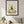 Nature at Play print in a black frame hanging in a living room