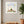 Quiet Joy Pose art in a white frame hanging in a serene yoga studio