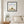 Quiet Joy Pose art in a black frame hanging in a calm bedroom