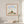 Quiet Joy Pose art in a red oak wood frame hanging in a bathroom