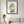Soft Harvest Lady art in a black frame in a living room