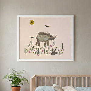 Little Rhino botanical baby rhino wall art print in a white frame hanging in a nursery
