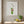 Wild Stem Vessel in a white frame hung in a bright kitchen